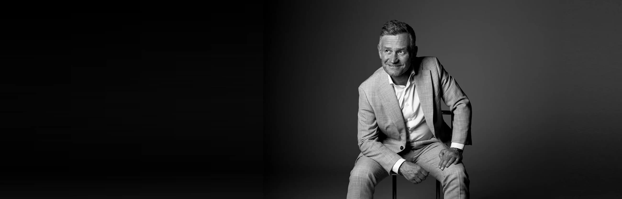 Black-and-white portrait of a coach seated confidently, illustrating team building activities based on MBTI
